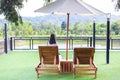 A woman sits on a lone wooden chair among the beautiful natural mountains