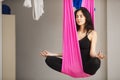 Woman sits in lotus pose in hammock practicing aerial yoga Royalty Free Stock Photo