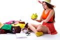 Woman sits near overfilled suitcase.