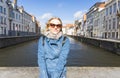 Woman sits near water on Jan van Eyck Square in Bruges, Belgium Royalty Free Stock Photo