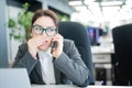 A woman sits in an office at her desk and gossips on the phone. Corporate ethics. Female employee in a suit tells