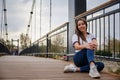 Woman sits on a pedestrian bridge