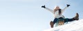 Woman sits and sledges from the mountain against the background of snow and sky in winter. Banner for ski resort