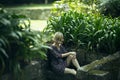 A woman sits on a stone bench among the greenery in an old park, Porto, Portugal. Royalty Free Stock Photo