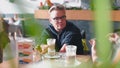 A woman sits at a table in a restaurant with an interlocutor.