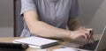 A woman sits at a table and writes data to a laptop. Royalty Free Stock Photo