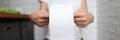 Woman sits on toilet and holds toilet paper in her hands.