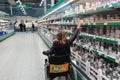 Woman sits in wheelschair and shopping