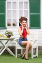 Woman sits at white wooden table with fruits and flowers Royalty Free Stock Photo