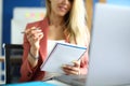 Woman sits at workplace with notebook pen in her hands. Royalty Free Stock Photo