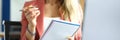 Woman sits at workplace with notebook pen in her hands. Royalty Free Stock Photo