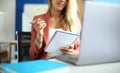 Woman sits at workplace with notebook pen in her hands. Royalty Free Stock Photo