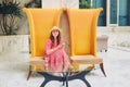 A woman sits on yellow high-backed chairs in the hotel lobby. Vacation at a resort in an arabic country. Rest in the Arab luxury