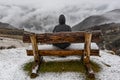 Woman sitted on a bench in a snowy day