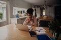 Woman sitting alone blowing nose while using laptop during work from home Royalty Free Stock Photo