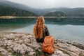 Woman Sitting Alone on Rock by Mountain Lake Royalty Free Stock Photo