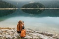 Woman Sitting Alone on Rock by Mountain Lake