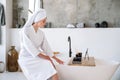 Woman sitting at bath, waiting until water fill the bathtub