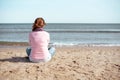 Woman sitting on the beach looking at the sea Royalty Free Stock Photo