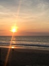 Woman Sitting on Beach Meditating at Sunset