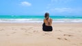 Woman sitting on the beach watching the sea