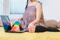 Woman sitting in bed and cleaning laptop keyboard Royalty Free Stock Photo