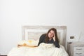 Woman sitting on bed irritated when they hear the alarm clock. E