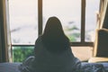 A woman sitting in the bed looking at beautiful sea view through the window Royalty Free Stock Photo