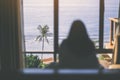 A woman sitting in the bed looking at beautiful sea view through the window Royalty Free Stock Photo