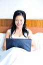 Woman sitting on the bed using her computer