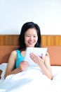 Woman sitting on the bed using her tablet