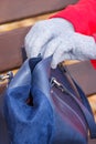 Woman sitting on bench in autum park and opening her handbag Royalty Free Stock Photo