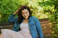 Woman is sitting on a bench and corrects her hair Royalty Free Stock Photo