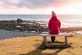 Woman Sitting on a Bench in Front of the Ocean In Iceland Royalty Free Stock Photo