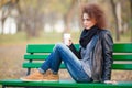 Woman sitting on the bench and holding cup with coffee Royalty Free Stock Photo