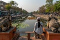 Woman is sitting on the bench and looking at the moat of Chiang Mai.