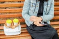 Woman sitting on the bench in the park with take away food and coffee Royalty Free Stock Photo