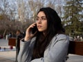 Woman sitting on a bench talking with her mobile in a park Royalty Free Stock Photo