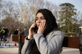 Woman sitting on a bench talking with her mobile in a park Royalty Free Stock Photo