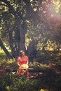 Woman sitting on the bench by the tree