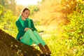 Woman sitting on big tree trunk Royalty Free Stock Photo