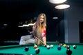 Woman sitting on billiard table and going hit ball Royalty Free Stock Photo