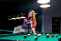 Woman sitting on billiard table and going hit ball Royalty Free Stock Photo