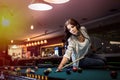 Woman sitting on billiard table going make a hit Royalty Free Stock Photo