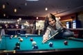Woman sitting on billiard table going make a hit Royalty Free Stock Photo