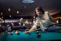 Woman sitting on billiard table going make a hit Royalty Free Stock Photo