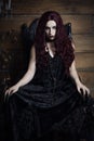 Woman sitting in a black Gothic throne Royalty Free Stock Photo