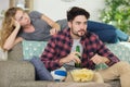 woman sitting bored while man watching sports Royalty Free Stock Photo