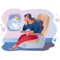 Woman is sitting in the cabin of the plane and looking through the porthole in which you can see the wing of the plane Royalty Free Stock Photo