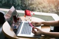 Woman sitting at cafe restaurant holding credit card with shopping online concept Royalty Free Stock Photo